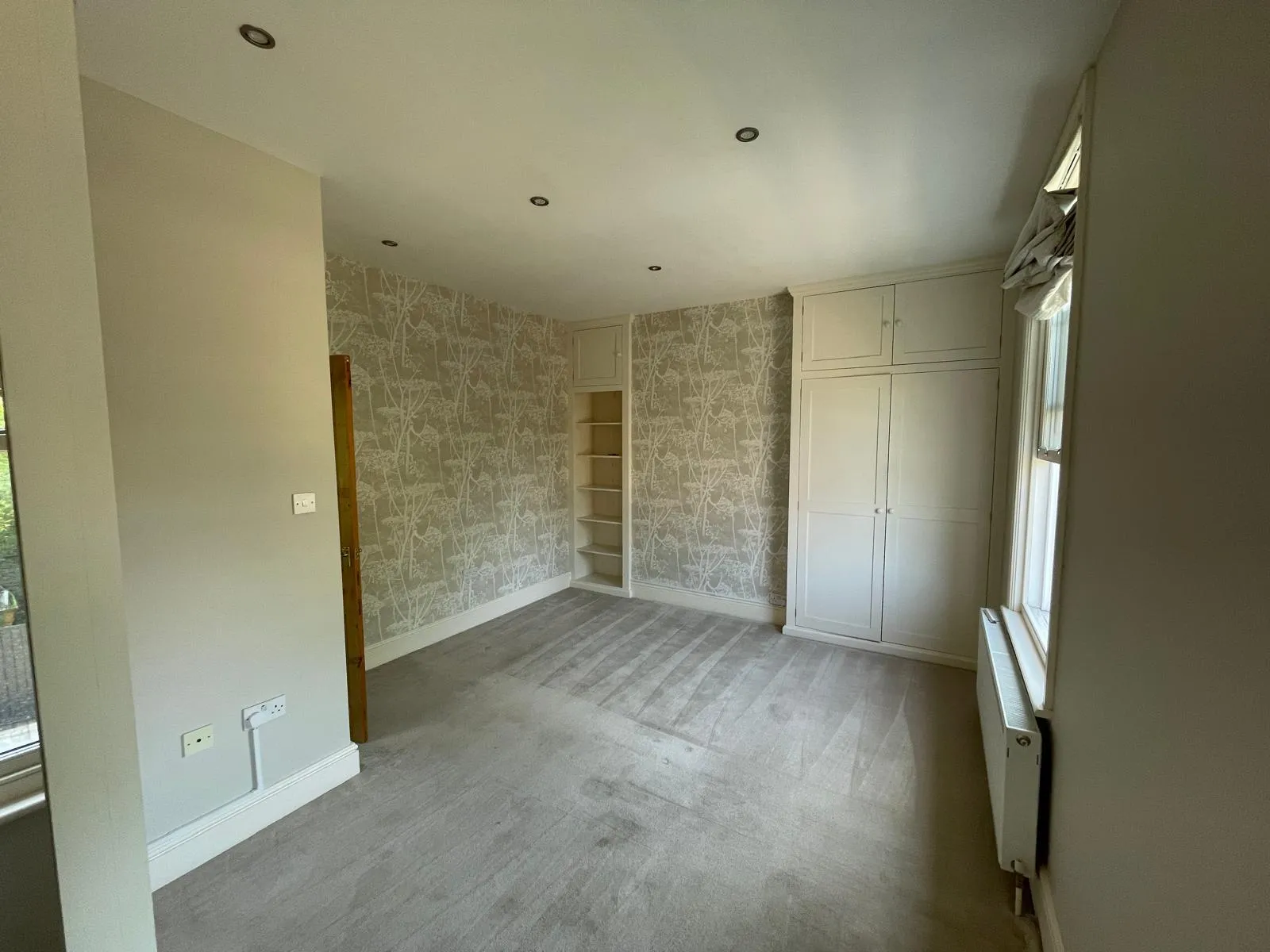 Wallpaper Removal: How to Strip It Properly and What to Do With the Wall Underneath 2 Living room with patterned wallpaper in the chimney alcoves, plain painted walls and grey carpet, alcove paper of the kind that needs careful wallpaper removal | Prestige Painting Solutions